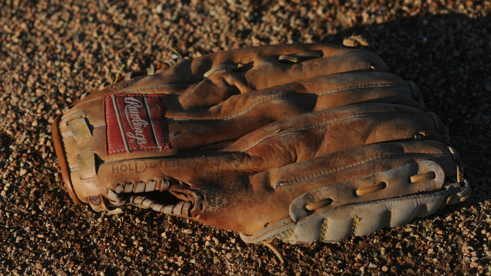 A baseball glove on the ground.