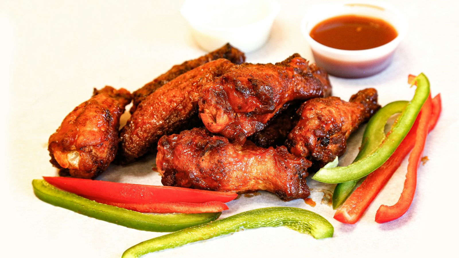 Chicken wings with bell peppers and sauce.